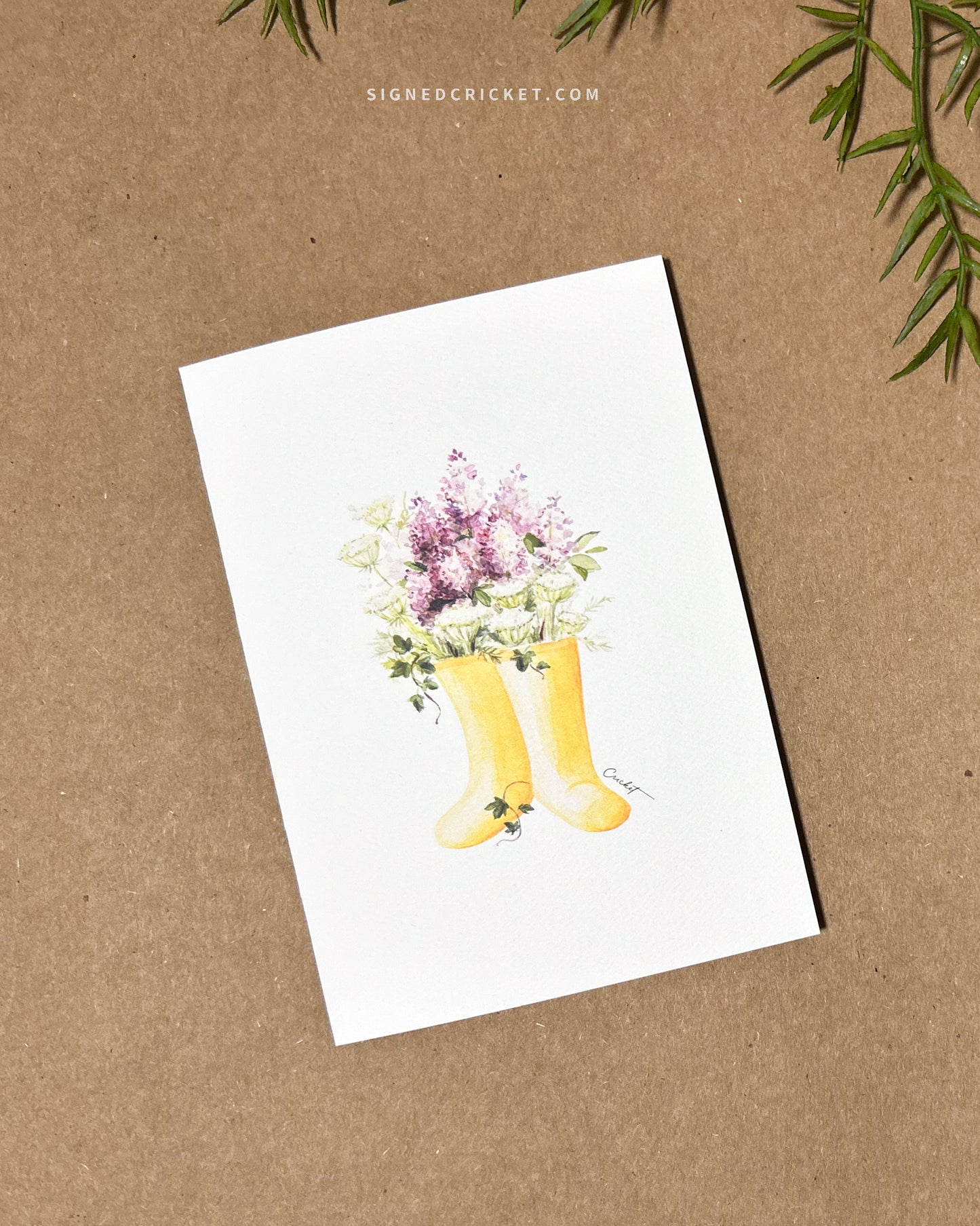 5x7 greeting card featuring watercolor illustration of yellow boots, purple liliacs, white and green Queen Anne's lace, and dark green English ivy
