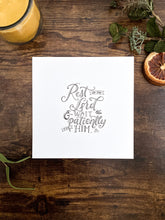 Load image into Gallery viewer, The art pictured is a square sheet of paper handlettered with the words &quot;Rest in the Lord and wait patiently for Him; Psalm 37:7&quot;. The piece is lying on a dark wood desk
